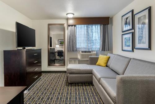 a living room with a couch and a flat screen tv at Comfort Inn & Suites Tigard near Washington Square in Tigard