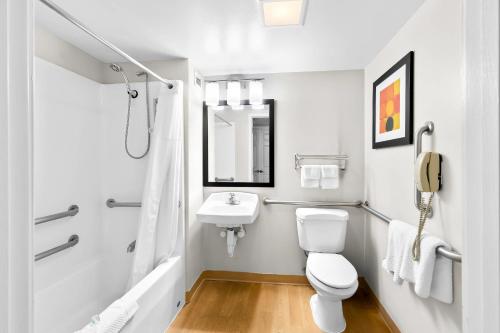 a white bathroom with a toilet and a sink at MainStay Suites Middleburg Heights Cleveland Airport in Middleburg Heights