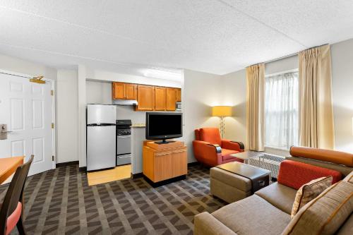 a living room with a couch and a kitchen at MainStay Suites Middleburg Heights Cleveland Airport in Middleburg Heights