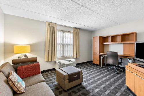 a living room with a couch and a desk at MainStay Suites Middleburg Heights Cleveland Airport in Middleburg Heights