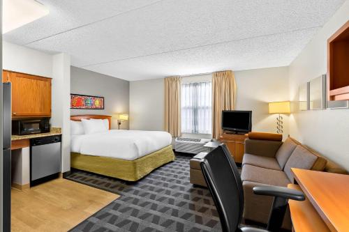 a hotel room with a bed and a couch at MainStay Suites Middleburg Heights Cleveland Airport in Middleburg Heights