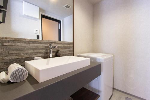 a bathroom with a white sink and a mirror at Hotel FUK O in Fukuoka