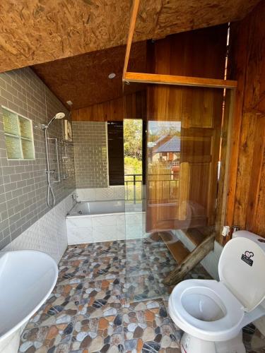a bathroom with a toilet and a tub and a sink at Min Land Resort in Ban Lan Nok