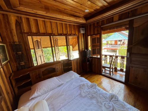 a bedroom with a bed and a large window at Min Land Resort in Ban Lan Nok