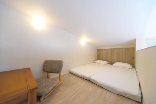 a bedroom with a bed and a desk and a chair at JAPANDI HOTEL Nagoya in Chikusachō