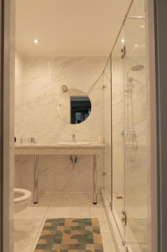 a bathroom with a sink and a shower with a mirror at Olympica Hotel in Almaty