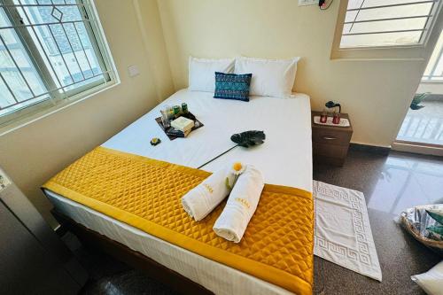 a bedroom with a bed with towels on it at Visaara Luxury Homes in Kammasandra