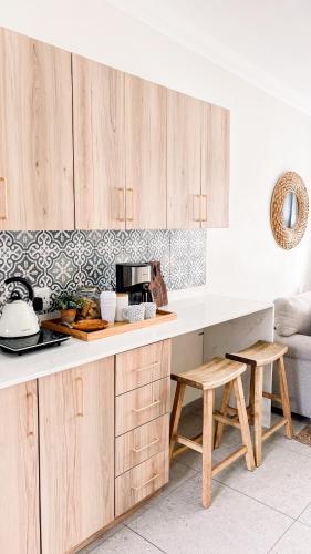 a kitchen with wooden cabinets and a counter with stools at The Halfway Homestead in Middelburg
