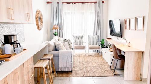 a white living room with a couch and a tv at The Halfway Homestead in Middelburg