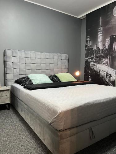 a bedroom with a large bed with a poster on the wall at Odnowiony Apartament Premium in Zawiercie