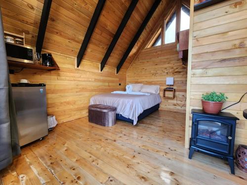 a bedroom with a bed and a fireplace in a log cabin at Brisas De Los Santos Lodge 1 in Sierra
