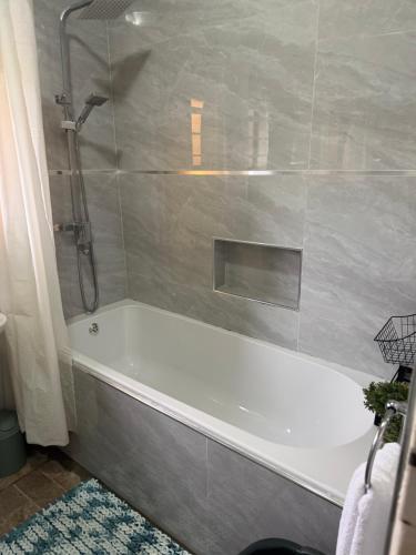 łazienka z białą wanną i prysznicem w obiekcie Java Tree Cottage w mieście Lusaka