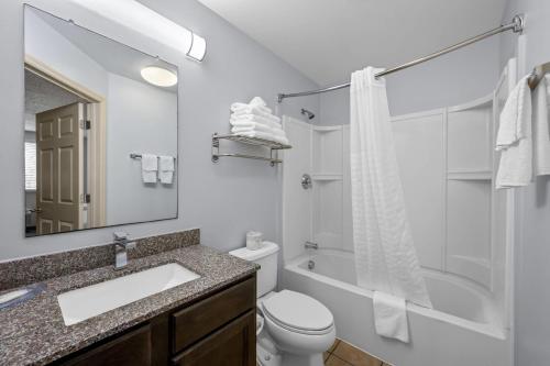 a bathroom with a sink and a toilet and a tub at Suburban Studios Near Camp Lejeune in Jacksonville