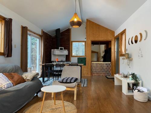 a living room with a couch and a table at Spa - River & Forest View - Le Petit Cocon in Chateau Richer