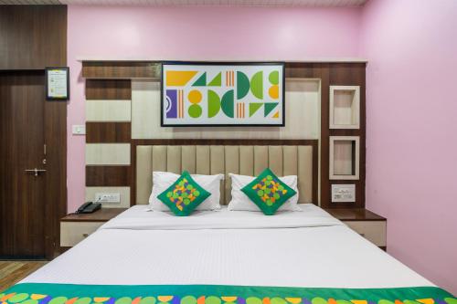 a bedroom with a large white bed with pillows at Treebo Saumendra Residency in Varanasi