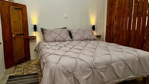 a large bed in a bedroom with two lamps at Magdalena in Cospicua