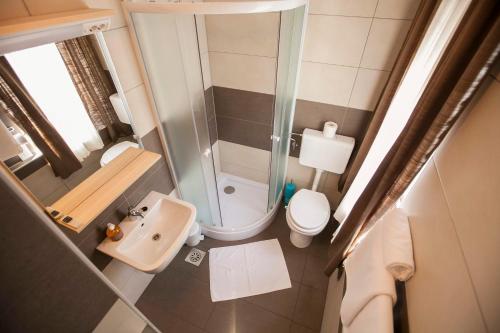 a small bathroom with a shower and a toilet at Postojna Rooms in Postojna