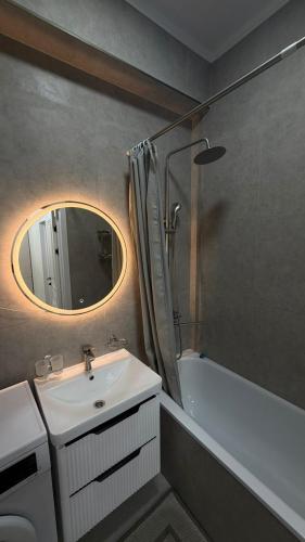 ein Badezimmer mit Waschbecken, Dusche und Spiegel in der Unterkunft Millennium in Bischkek
