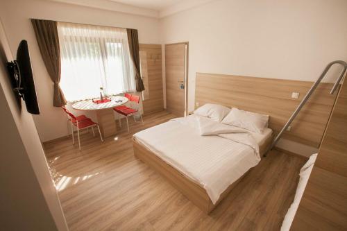 a bedroom with a bed and a table and a window at Postojna Rooms in Postojna