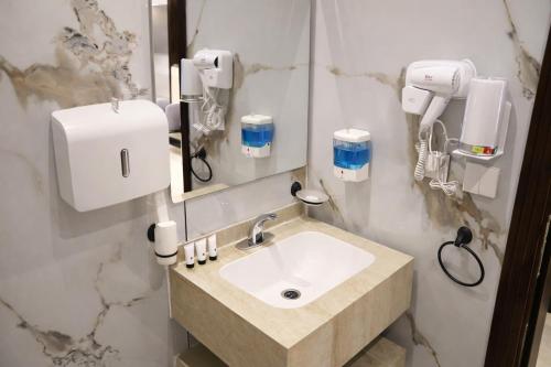 a bathroom with a sink and a mirror at Almawasem Alarbaa for Serviced Apartments - Standard in Al Jubail