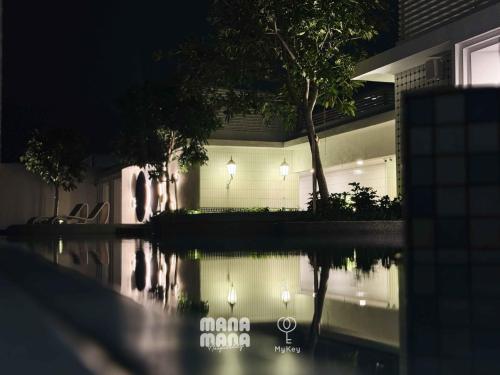 a night view of a house with a reflection in the water at Stallionz by MyKey in Ipoh