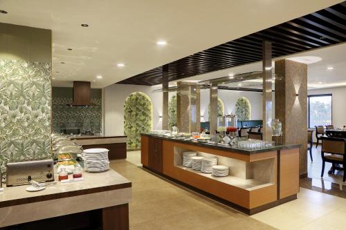 a restaurant with a counter with plates on it at Parays Fernwoods in Mannārakkāt