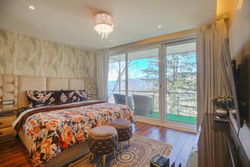 a bedroom with a bed and a large window at Samar Villa BnB in Shimla