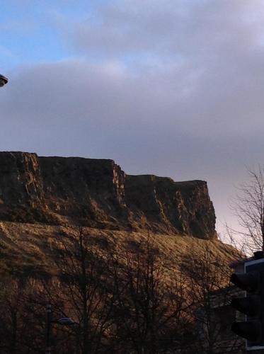 a view of a mountain with trees in front of it at The Queens View in Edinburgh