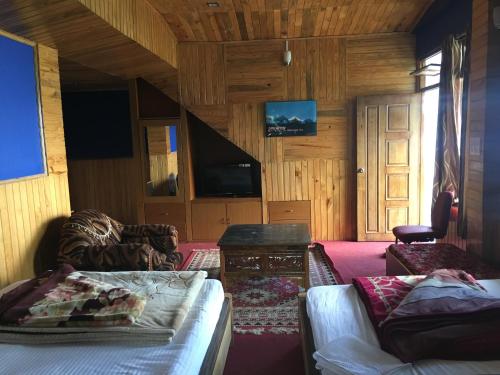 a room with a bed and a tv and a couch at Hotel Aditya in Aritar