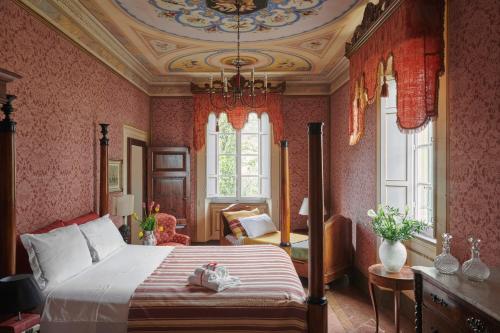 a bedroom with a bed and a chandelier at Villa Pedone in Lucca