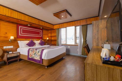 a bedroom with a large bed in a room at Conifer Suites & Spa Darjeeling in Darjeeling
