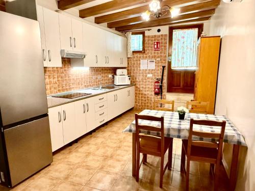 a kitchen with a table and chairs and a refrigerator at Rapia. Casa Beig 4 in Los Granadicos