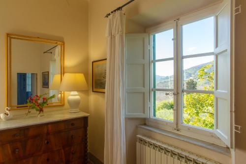 a bathroom with a window and a dresser and a mirror at Villa Pedone in Lucca