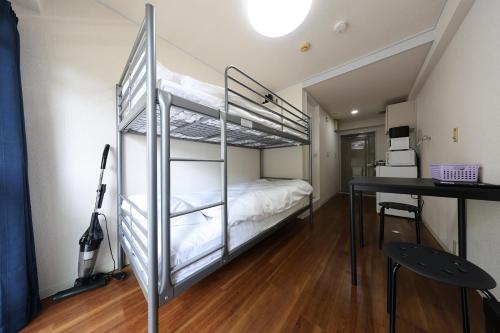 a bedroom with a bunk bed and a desk at Tsurumai Nagoya Stay in Nagoya
