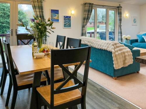 a dining room with a table and a blue couch at 9 Trehawks in Roche