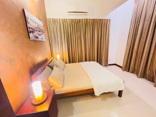 a bedroom with a bed and a candle on a table at Barnes Loft Mount in Mount Lavinia