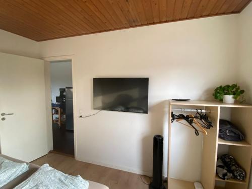 a living room with a flat screen tv on the wall at Charming Private Apartment in a Villa by the Forest in Sønderborg