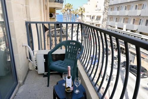a balcony with a chair and a bottle of wine at Sharon Court Guesthouse in St. Paul's Bay