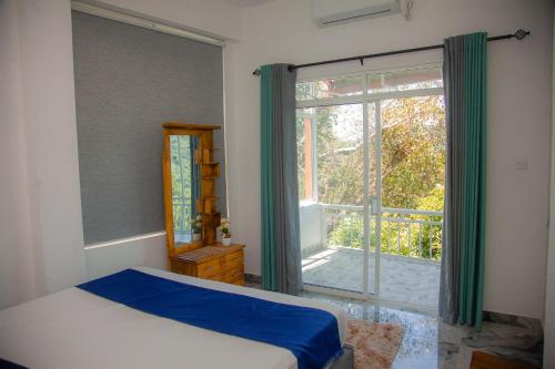 a bedroom with a bed and a large window at Celenika Resort in Kandy