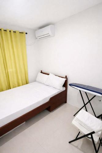 a small bedroom with a bed and a chair at Ben & Ben 1 in Cebu City