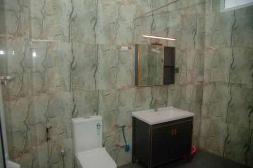 a bathroom with a toilet and a sink and a mirror at Celenika Resort in Kandy