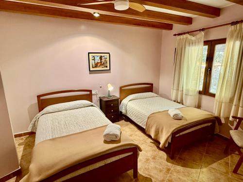 a bedroom with two beds and a window at RAPIA Casa Beig 5 in Moratalla