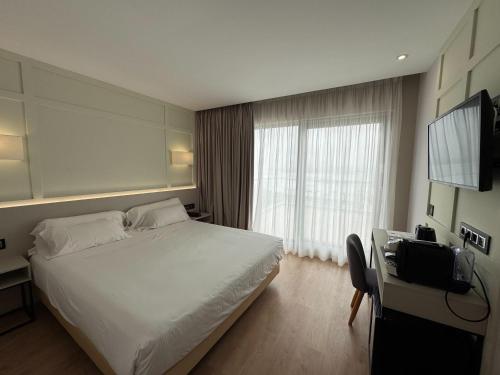 a hotel room with a bed and a television at Playa de Foz Hotel & Spa by gaiarooms in Foz
