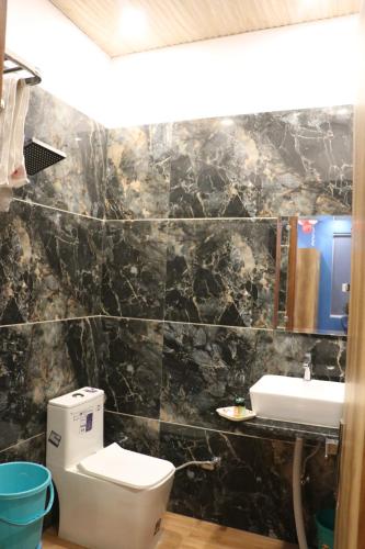 a bathroom with a toilet and a sink at Red Leaf Hotel in Māler Kotla