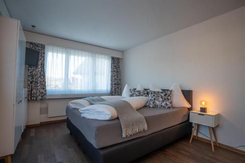a bedroom with a bed and a large window at Hotel B&B Stossplatz anytime and easy self Check-in in Appenzell