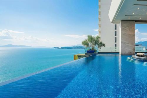 a swimming pool with a view of the ocean at Boton Blue Hotel & Spa in Nha Trang
