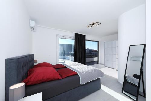 ein Schlafzimmer mit einem roten Bett und einem großen Fenster in der Unterkunft Astur in Zadar