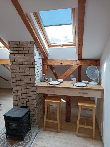 a room with a wooden table and a stove at Vėtrungėlė in Nida