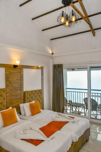 a bedroom with two beds with a view of the ocean at Chill Berg Resort - Bodimettu in Theni
