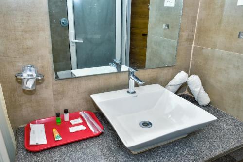 a bathroom with a white sink and a mirror at Chill Berg Resort - Bodimettu in Theni
